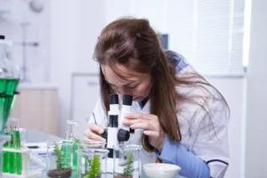 female scientist looking through microscope research lab